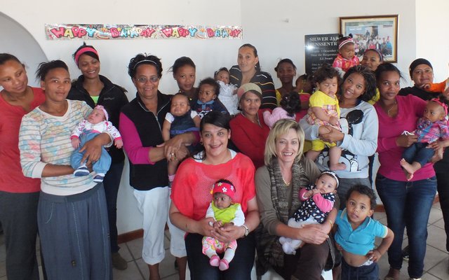 Die groot groep mammas met hul babas, met die beoordelaars, Rochelle de Villiers en Antoinette Louw voor - elk met â€˜n baba op die skoot